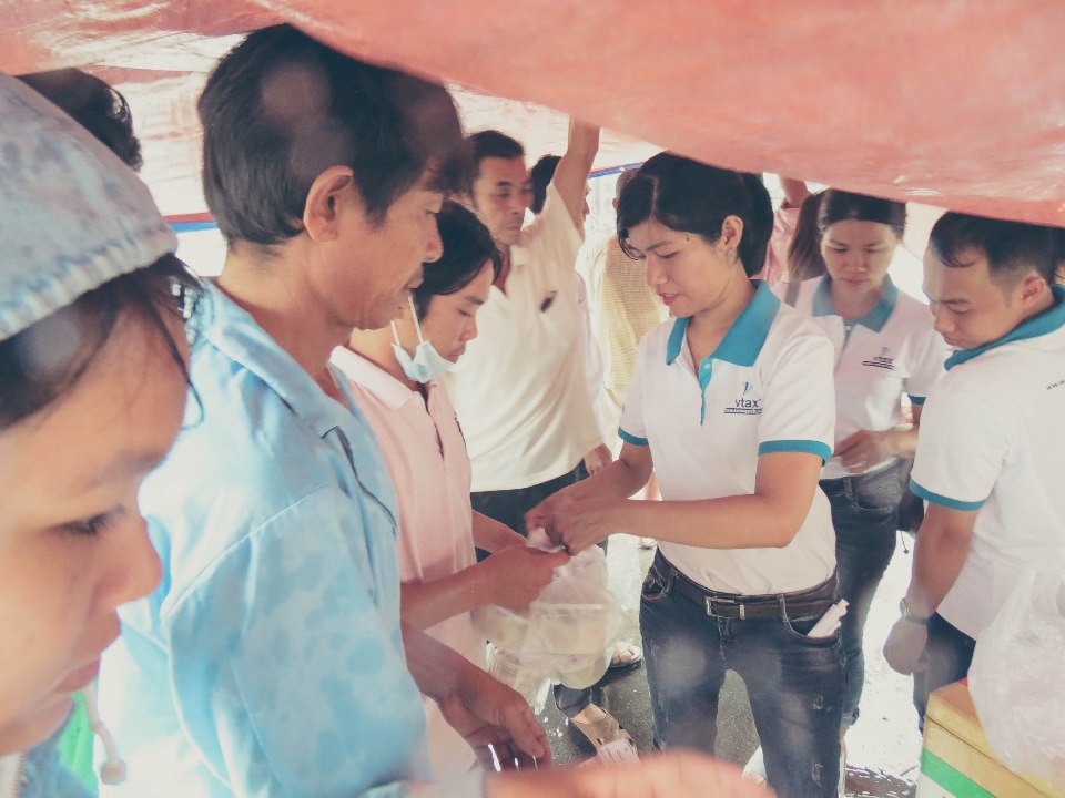 Các thành viên VTAX trao tặng cháo cho mọi người