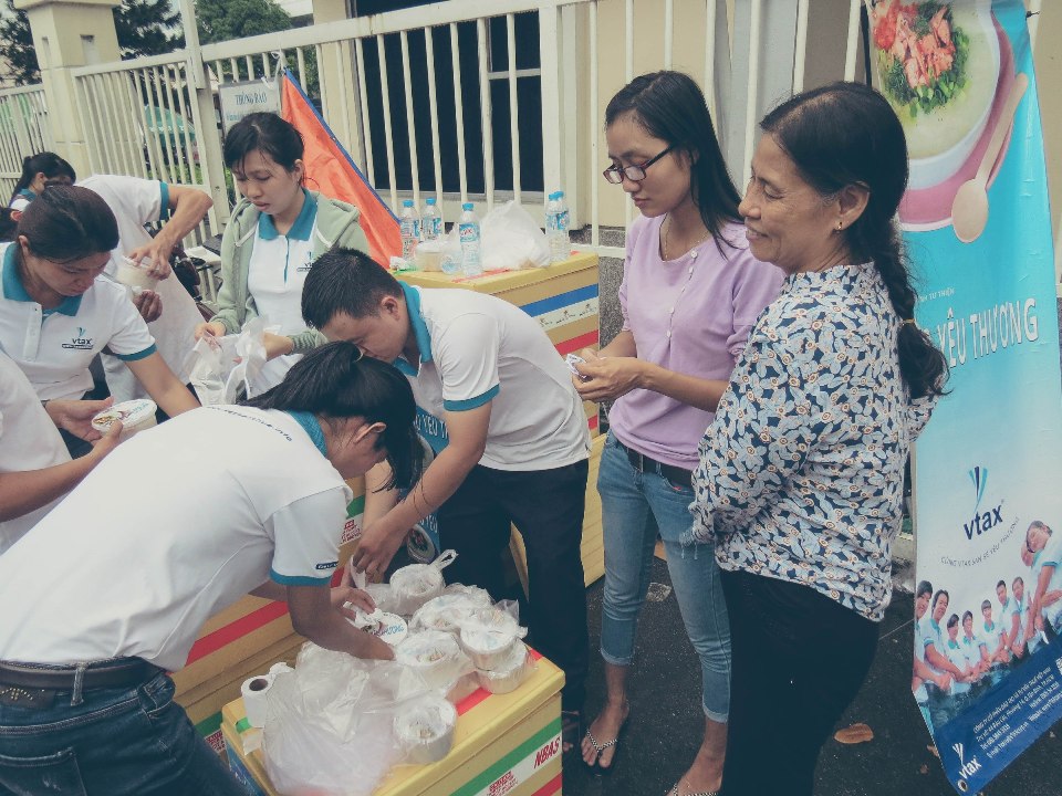 Các thành viên VTAX trao tặng cháo cho mọi người