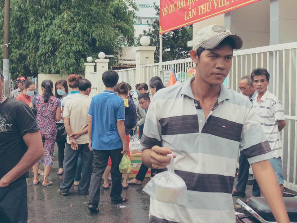 Mọi người nhận những hộp cháo yêu thương từ VTAX