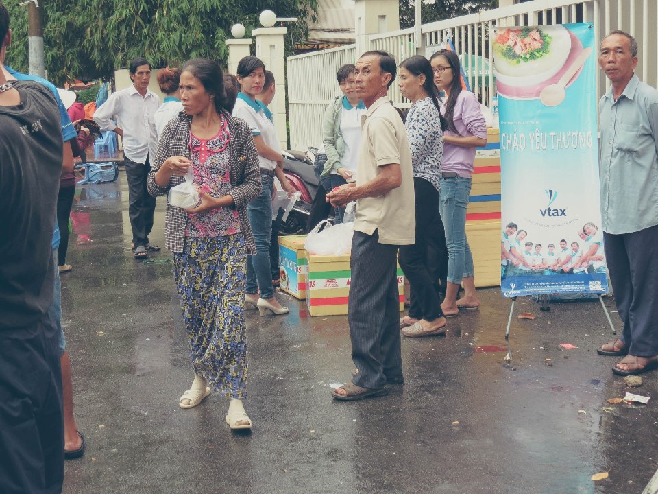 Mọi người nhận những hộp cháo yêu thương từ VTAX