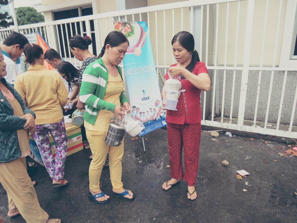 Mọi người nhận những hộp cháo yêu thương từ VTAX